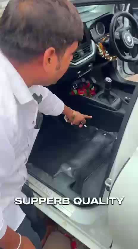 Still from supplied footage showing a Carzio mat fitting detail in the front footwell